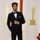 Andrew Garfield poses on the champagne-colored red carpet during the Oscars arrivals at the 95th Academy Awards in Hollywood, Los Angeles, California, U.S., March 12, 2023. REUTERS/Eric Gaillard